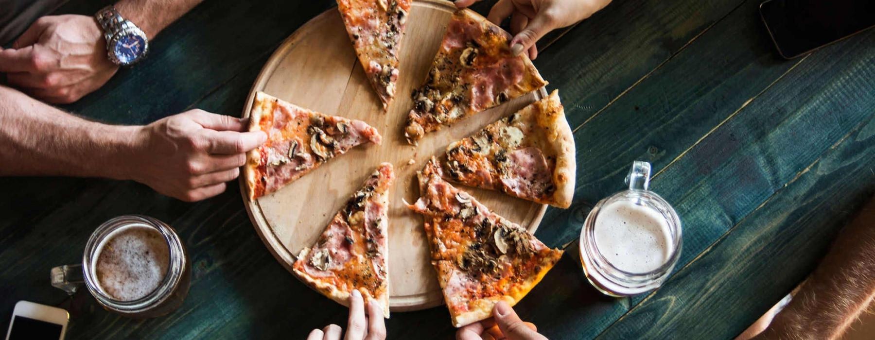 a group of people eating pizza